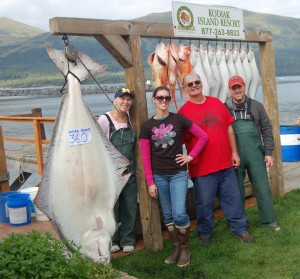 Jan, Shelby and Bob Arnold are shown with prospective family addition Justin rogers by Bob's lodge record halibut.