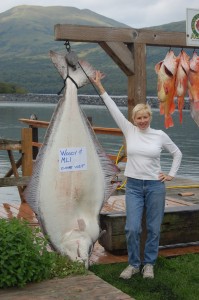 April Meffert poses with resort record halibut caught bt long time client Bob Arnold of Michigan.